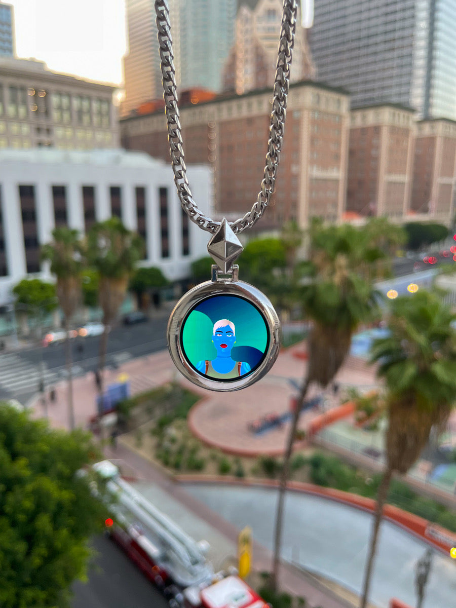 Round silver Google Watch pendant on a chain hanging in front of Los Angeles palm trees and buildings